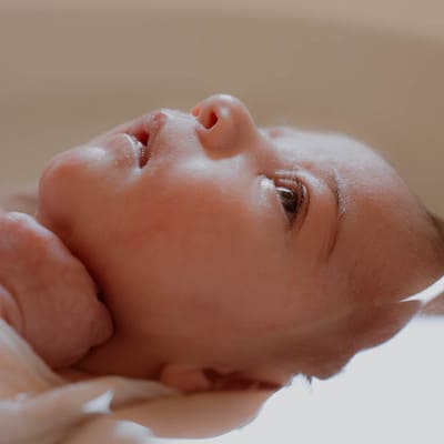 Bain de nouveau-né encadré par une professionnelle en périnatalité, accompagnement bienveillant